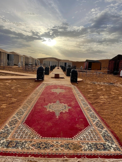       Desert camp with traditional tents and rugs.
  