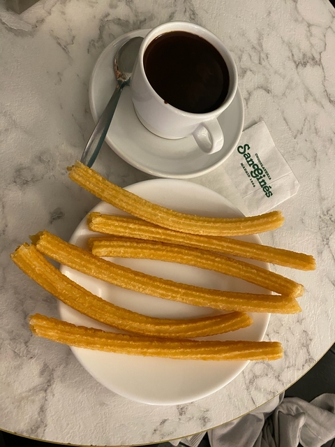       Plate of churros with a chocolate dipping sauce.
  