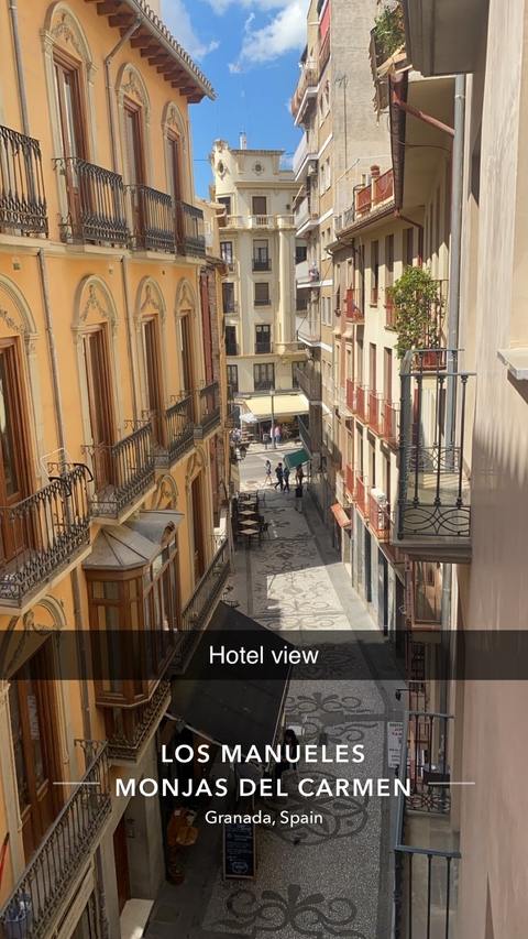 Aerial view of a narrow street with balcony railings.
