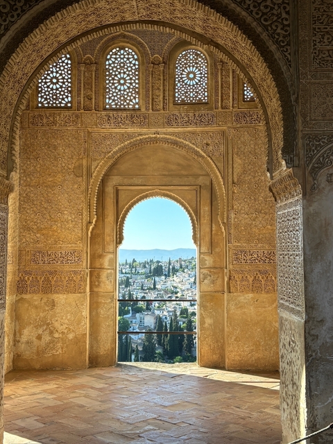       View through an ornate archway to a cityscape.
  