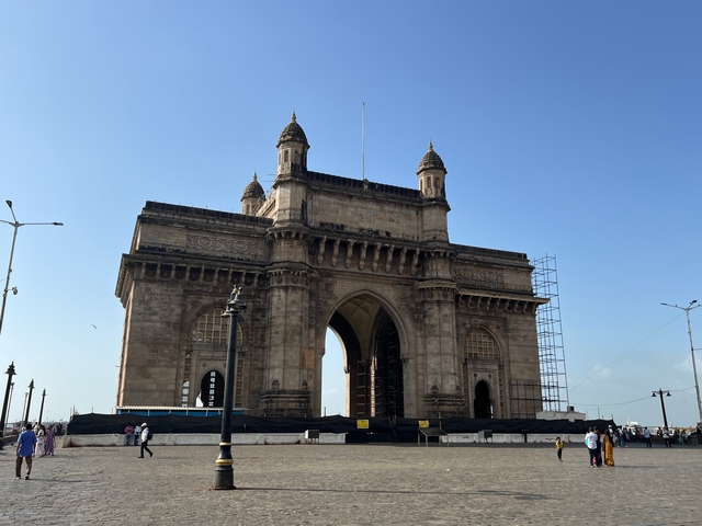       Gateway of India by the harbor with a clear sky.
  