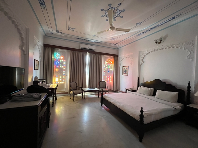       Richly decorated hotel room with colorful stained-glass windows.
  