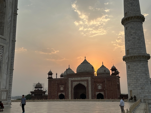       Taj Mahal at sunset with silhouetted dome and minaret.
  