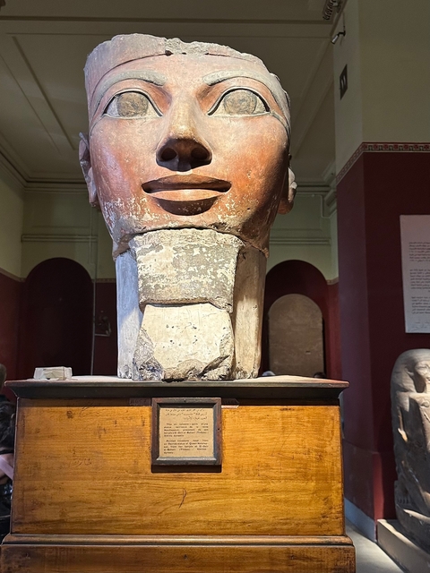       Close-up of an ancient statue displayed in a museum.
  