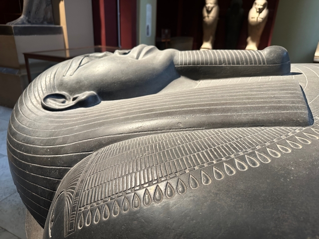       Egyptian sarcophagus carving displayed in a museum.
  