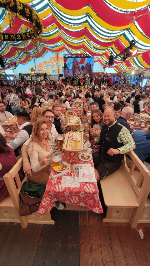 People at a festival table filled with food and drinks.