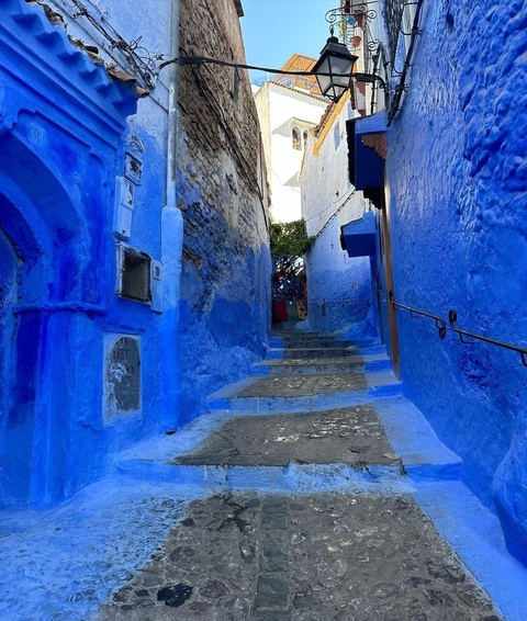       A narrow alley painted in bright blue.
  