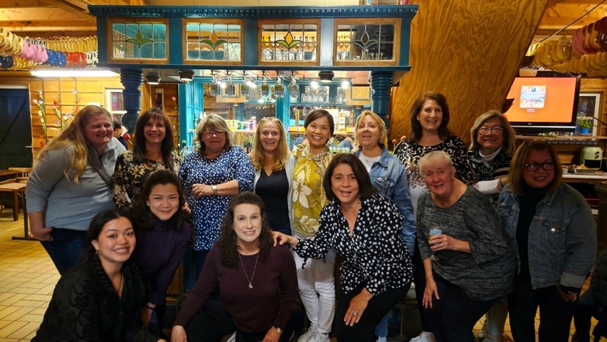 Group of women posing inside a decorated venue.