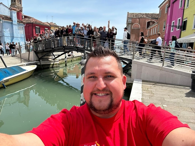 Selfie with a canal and bridge in the background.