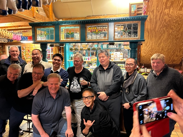Group of men posing inside a decorated venue.