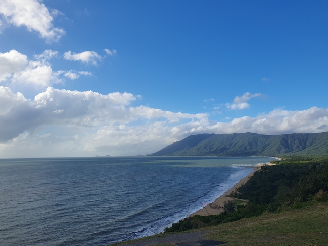 Picturesque view of the coastline with mountains in the distance.