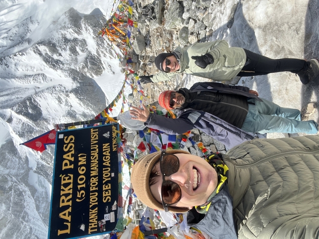       Group of people on a mountain pass with flags.
  