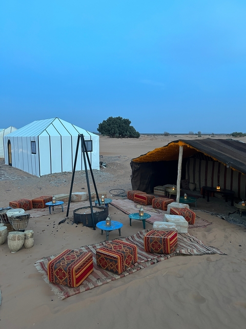 Desert camp with traditional tents and seating.