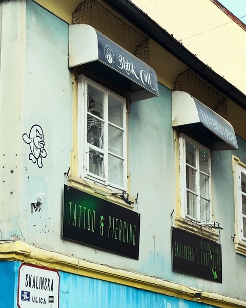      Tattoo shop exterior with signage and decorative additions.
  