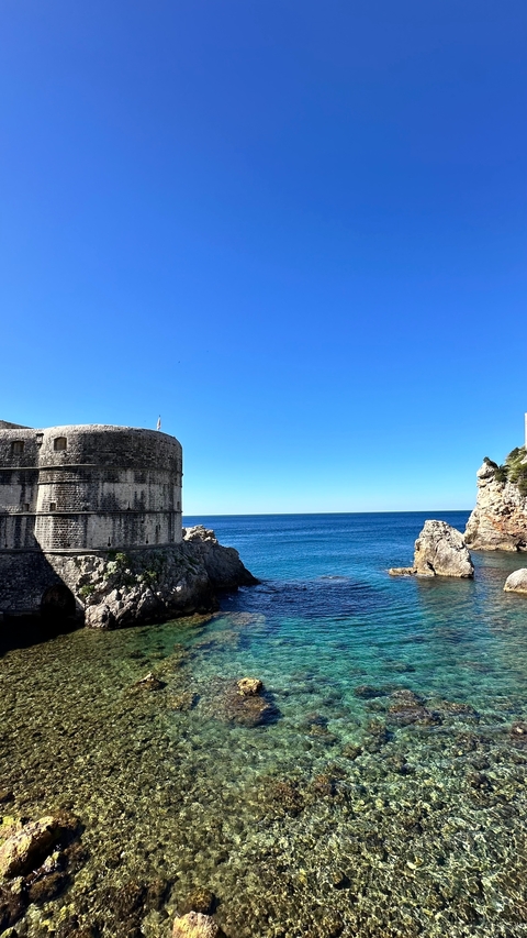       Historic fort by the sea with clear blue waters.
  