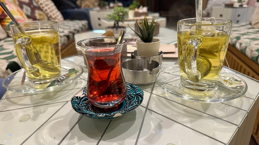 Three glasses of tea on a table with decoration.