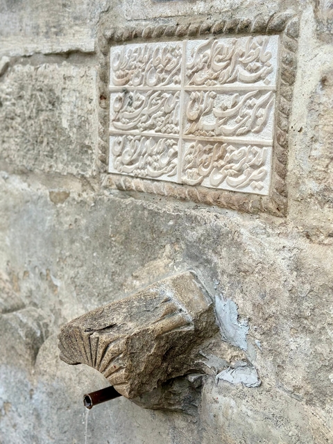 Ancient stone wall with engraved script.