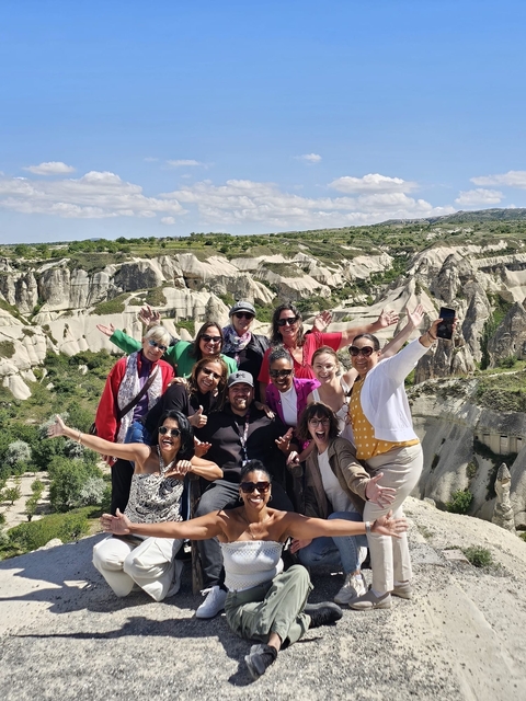 Group posing enthusiastically with rock formations in background.