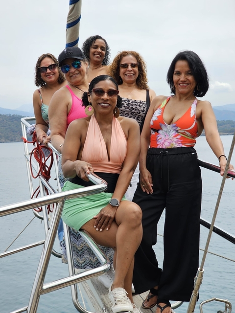       Group of women on a yacht with the sea in the background.
  