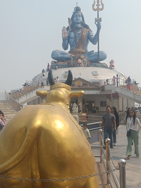       Sculpture with visitors around a temple complex.
  
