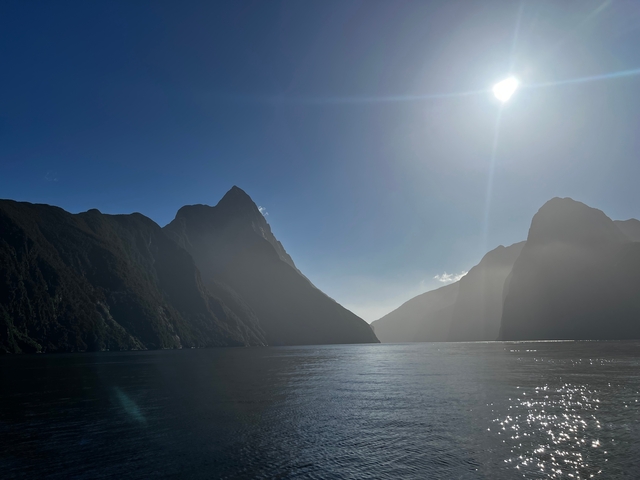       A towering mountain landscape with sunlight breaking through.
  