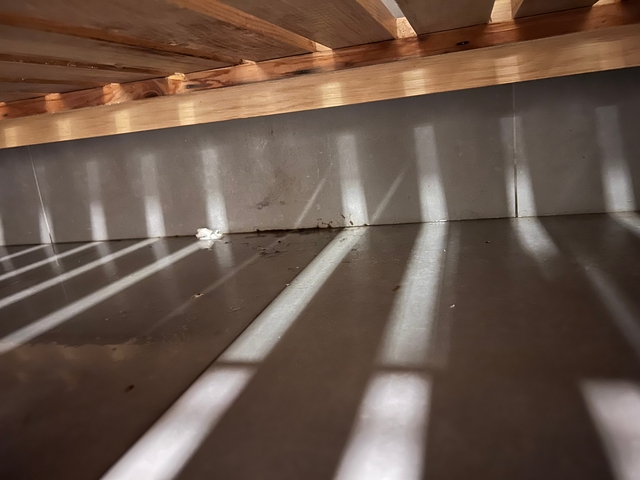       A floor with shadows and dirt.
  