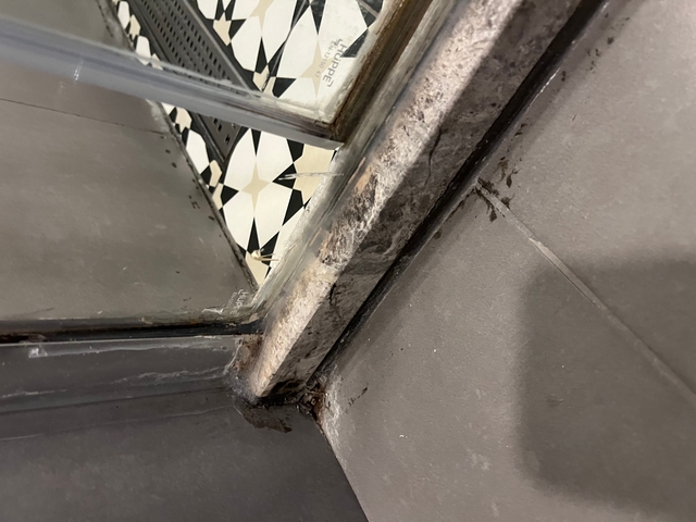       Detail of a shower area with signs of wear.
  