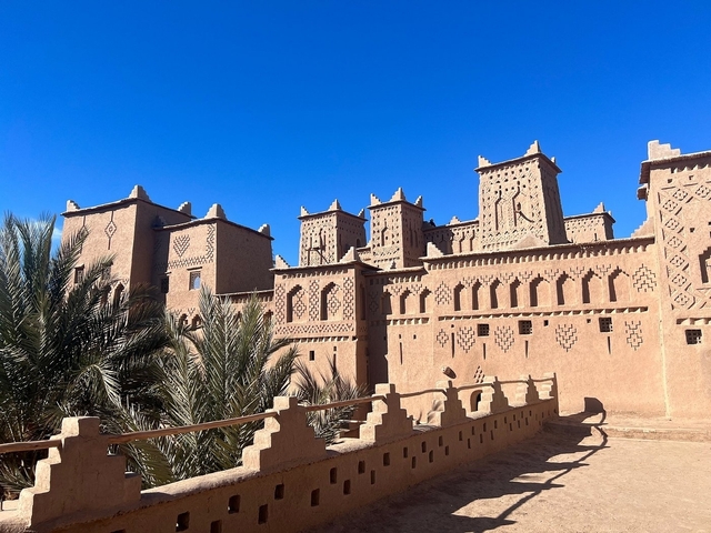 Traditional Moroccan fortress with palm trees.