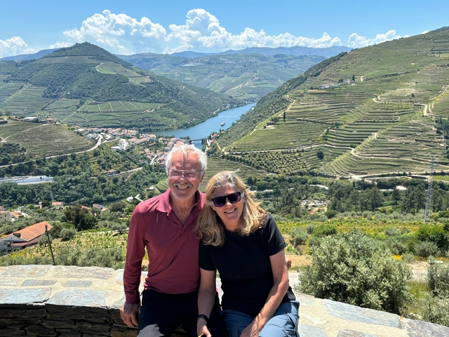 Couple posing with terraced vineyard landscape in the background.