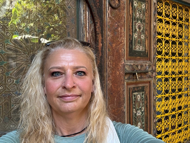 Portrait of a woman against a decorative background.