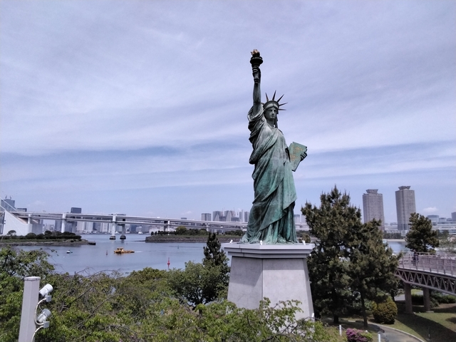 Statue of Liberty replica with city skyline in the background.