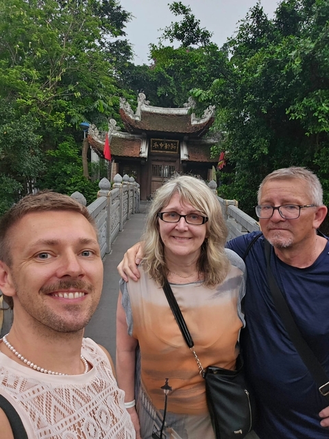 Three people posing in front of a traditional building.