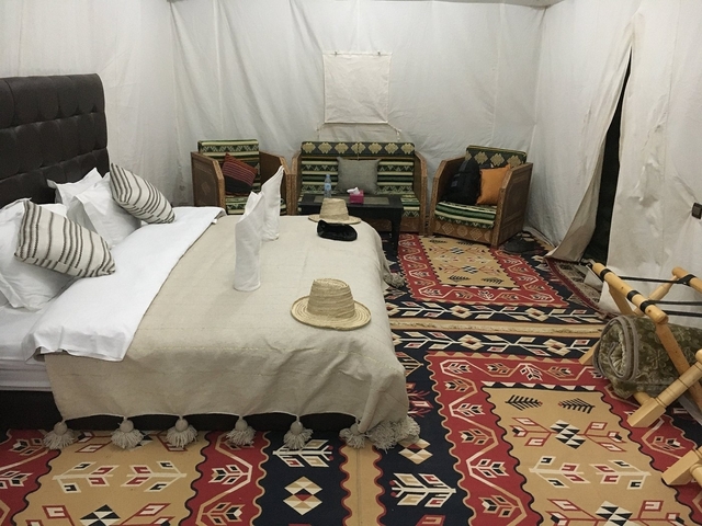 Interior of a traditional tent with beds and seating.