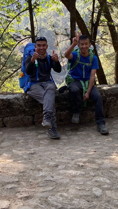 Hikers sitting on a stone ledge with hiking gear.