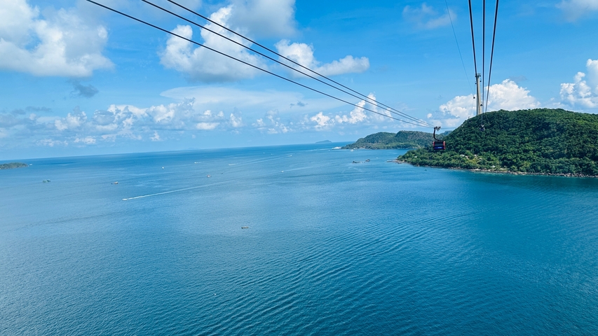 Panoramic view of the sea with a cable car over water.