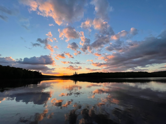       Beautiful sunset over a lake with colorful clouds.
  