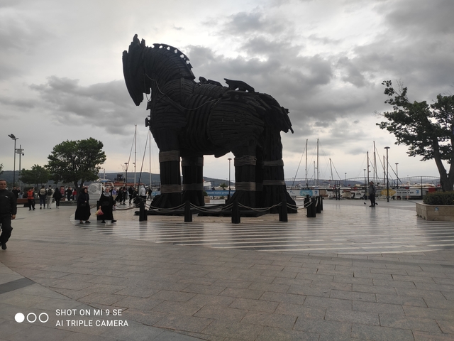 Statue of the Trojan Horse in a plaza by the sea.
