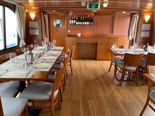       Elegant dining area with wooden tables and chairs set for a meal.
  