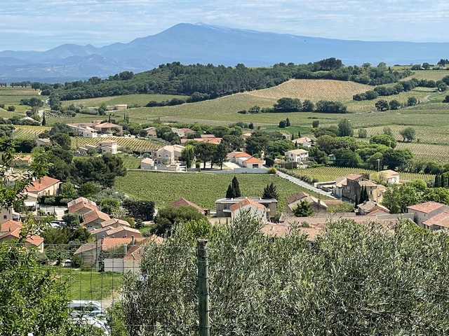 Aerial view of a countryside landscape with fields and rooftops.