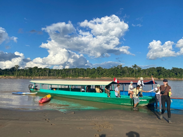       People enjoying a day by the river with boats.
  