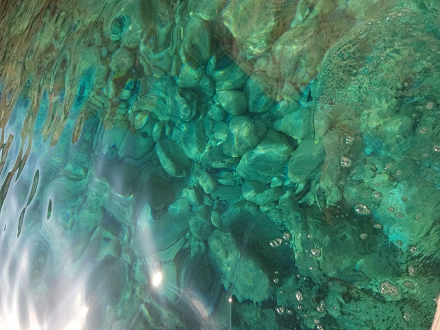 Turquoise waters with visible rock formations underneath.