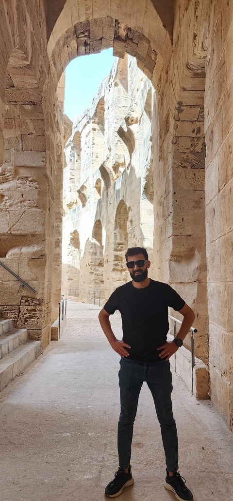 Person standing inside a historical stone structure.