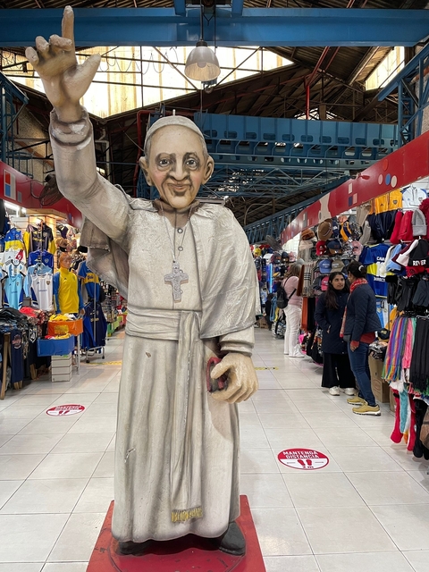 Life-sized statue of a religious figure in a market setting