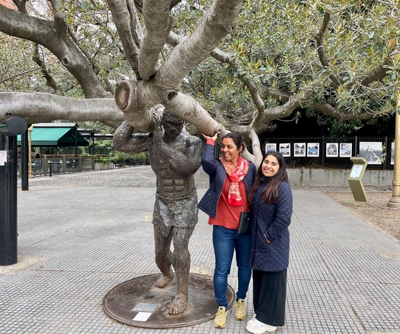       Statue of a football player with two women nearby
  