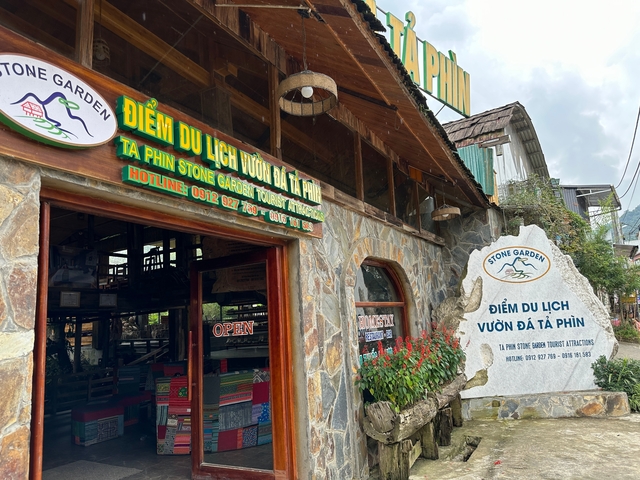      Tourist site with stone building and sign in Vietnamese.
  