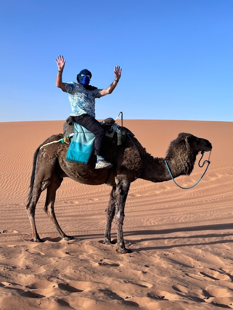 Person riding a camel in a desert.