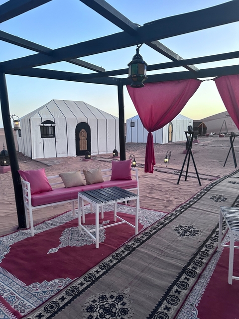 Desert camp with tents and seating area.