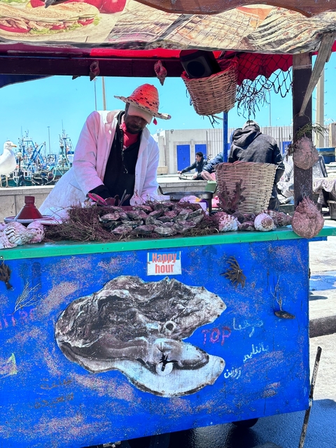 Seafood vendor at a market with a happy hour sign.