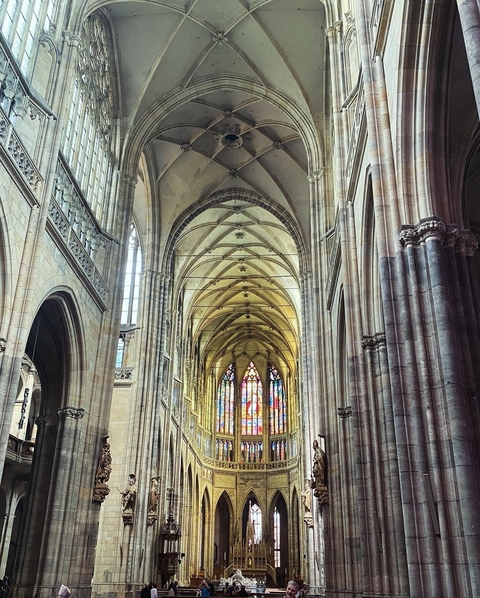 Interior of a Gothic-style cathedral with stained glass windows.
