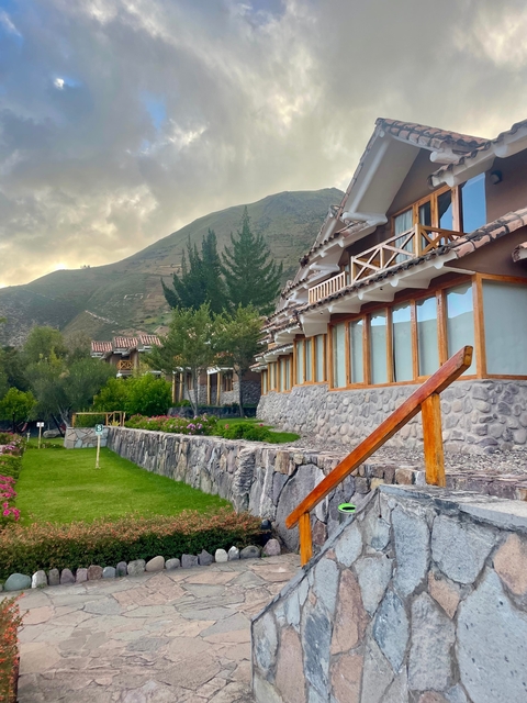       Resort with landscaped gardens set against a mountainous backdrop.
  
